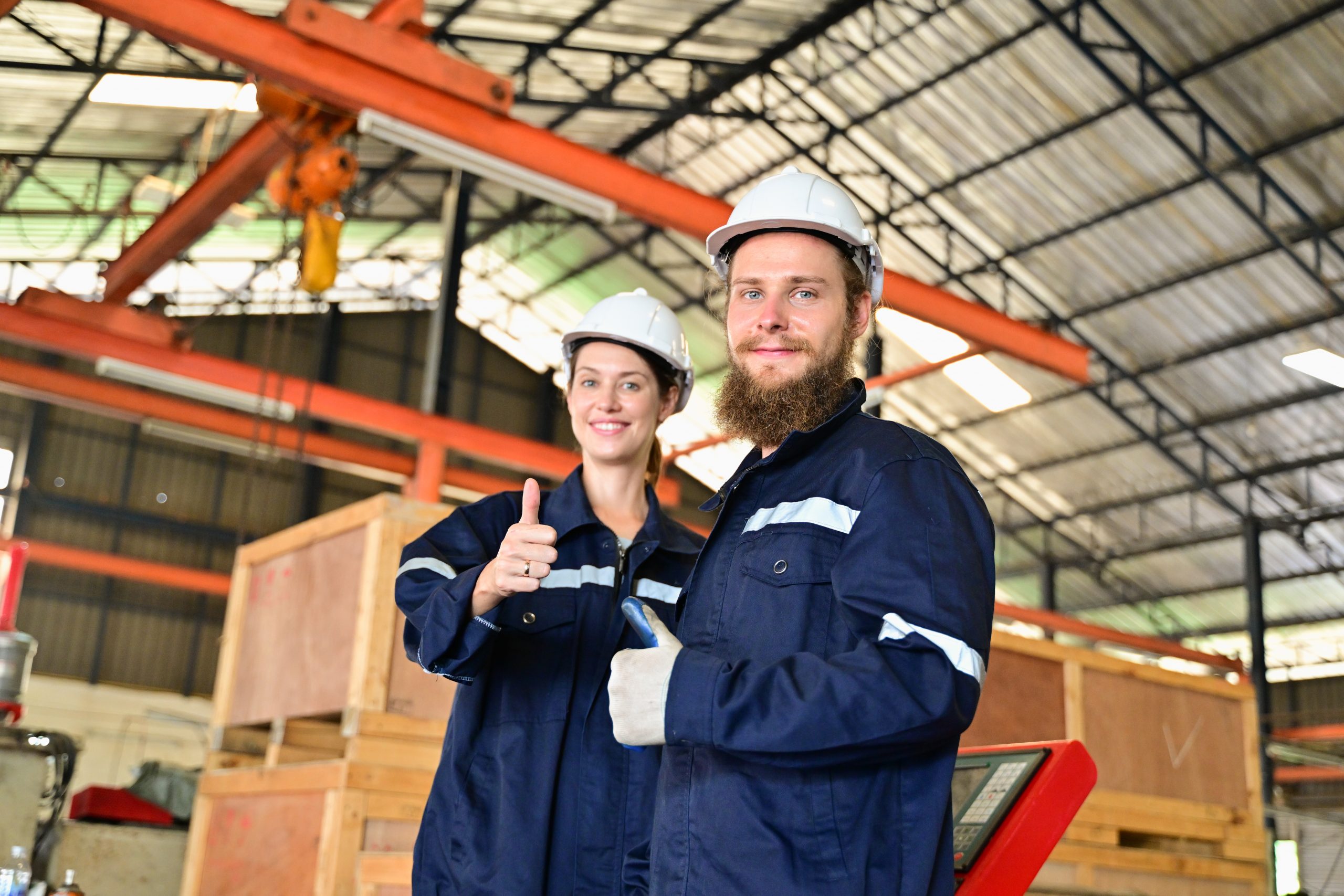 two employees giving a thumbs up in a warehouse